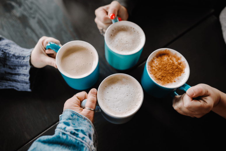 Friends Holding Lattes At Coffee Shop In Fenton Michigan