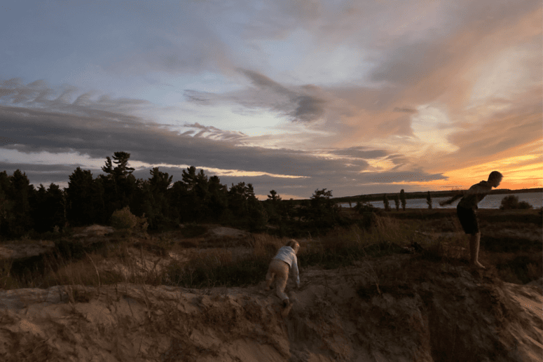 Kids Play On Dunes At Sunset