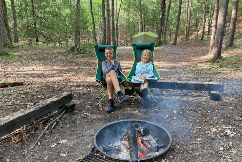 Kids Gathered By Fire Reading Books.