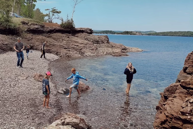 Family Skipping Rocks On Lake Superior In Presque Isle Park, Marquette, Mi