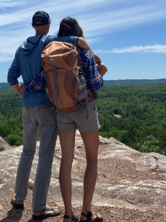 A Couple Embracing At The Top Of A Mountain.