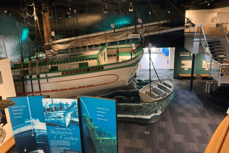 A Museum With An Old Ship Display And Signs With Facts On Shipwrecks.
