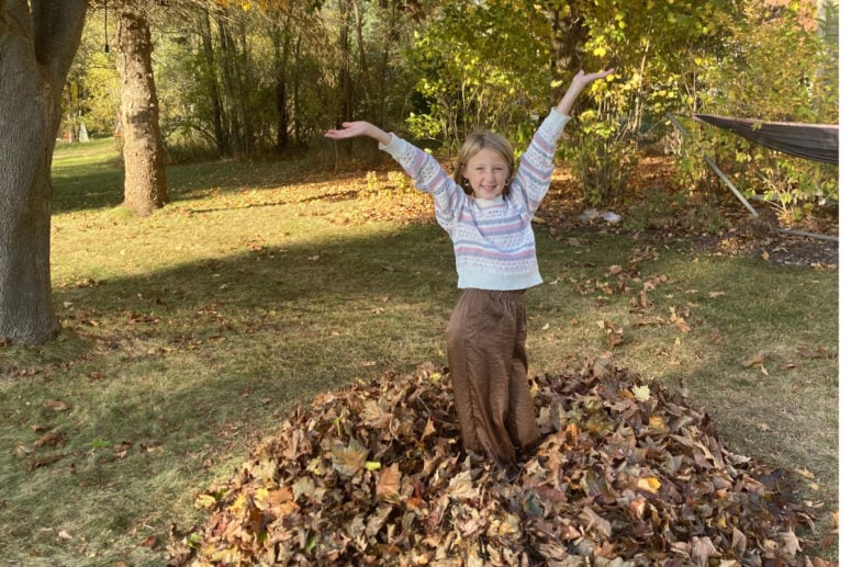 A Girl Throwing Leaves In The Air.